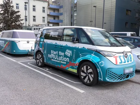 VW ID. Buzz mit passend foliertem Anhänger auf einem Parkplatz