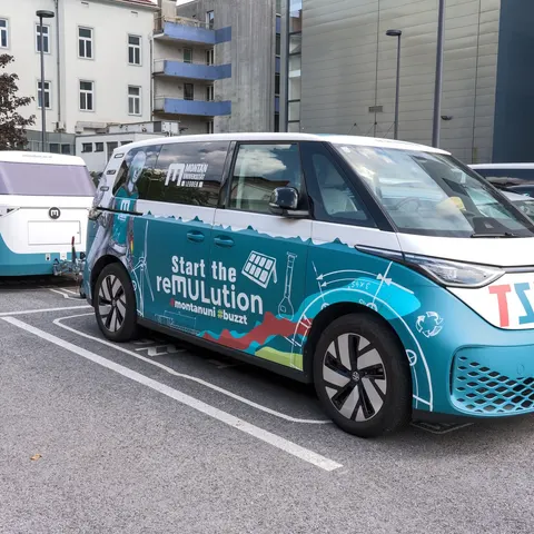 VW ID. Buzz mit passend foliertem Anhänger auf einem Parkplatz