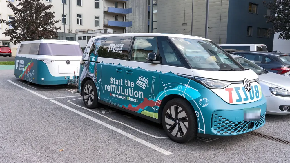 VW ID. Buzz mit passend foliertem Anhänger auf einem Parkplatz