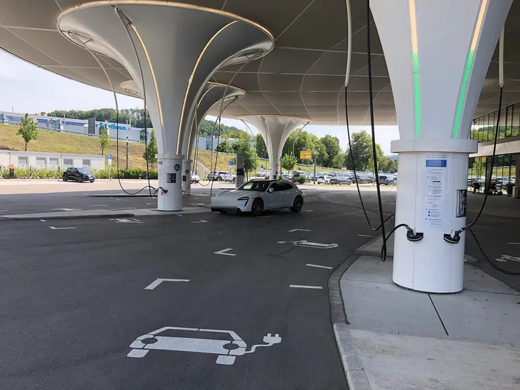 Porsche Taycan lädt in einem überdachten Ladepark mit HPC-Ladesäulen
