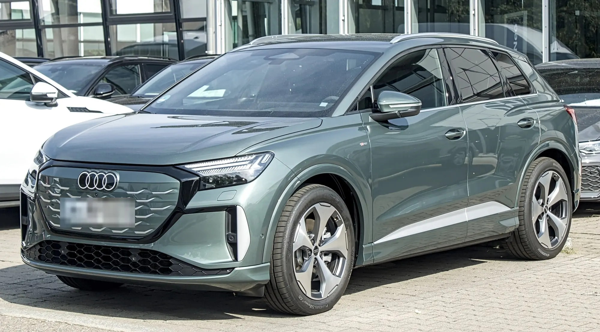 Audi Q4 e-tron (Facelift 2026) in Graugrün, schräge Frontansicht