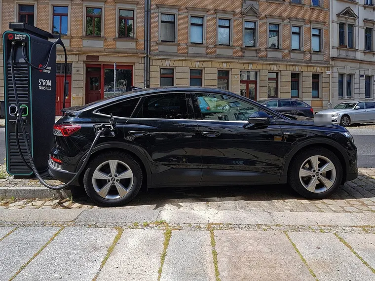 Audi Q4 e-tron lädt an einer Schnellladesäule mit fest angeschlagenem CCS-Kabel