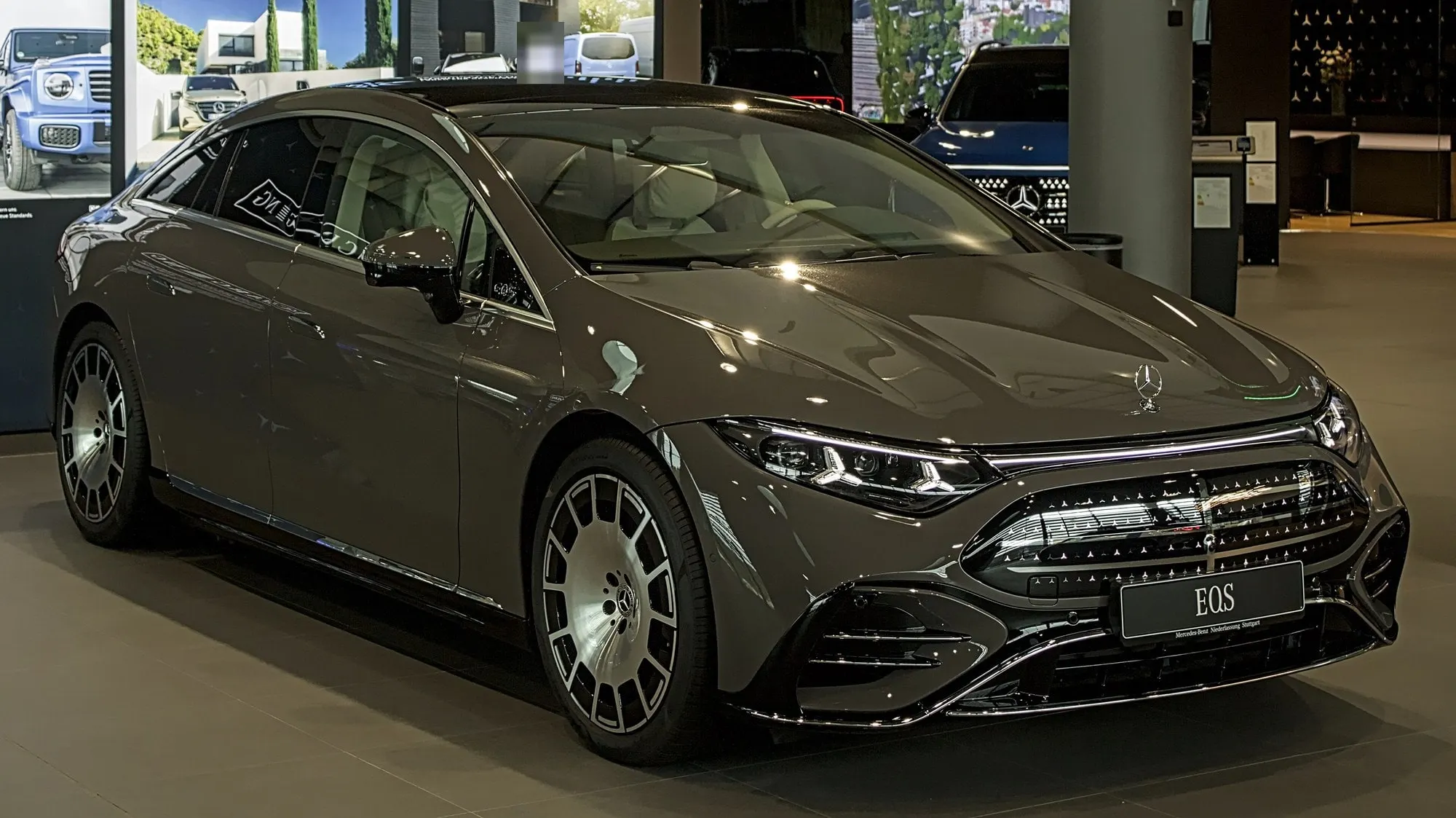 Mercedes-Benz EQS (V 297, ab 2026) in Grau, schräge Frontansicht im Showroom