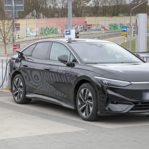 Schwarzer VW ID.7 lädt mit Ladekabel an einer Wallbox