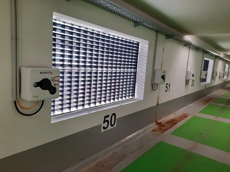 Reihe von Wallboxen an den nummerierten Stellplätzen einer Tiefgarage